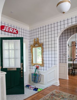 An entryway with wallpaper and a wall hook to hang coats