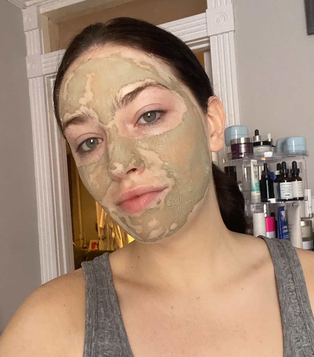 Katie Behron wearing a clay mask.