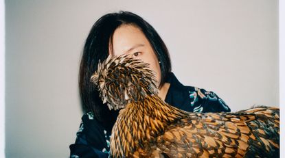 Chinese artist Cao Fei photographed with her chicken