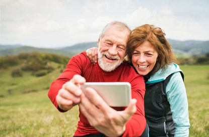 Older couple takes a selfie while out hiking in the mountains