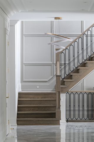 A wooden staircase with white panels