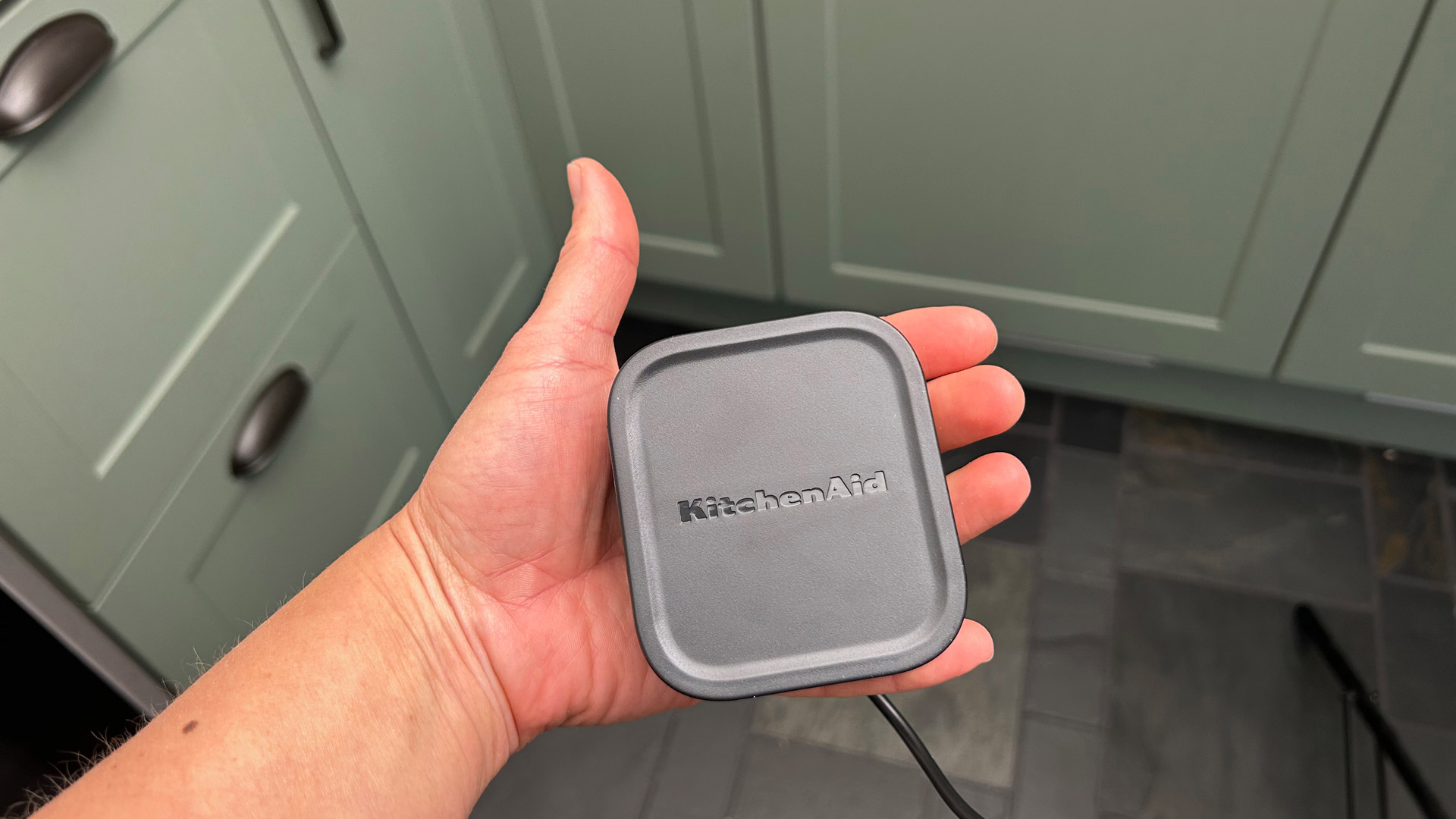A hand holding the KitchenAid Go Cordless Food Chopper's battery