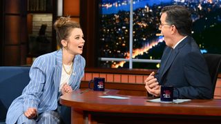 Claudia on The Late Show with Stephen Colbert with a blue suit and white t-shirt