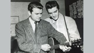 Sun Records owner Sam Phillips and Elvis Presley both fingering a chord on the same guitar, United States, 1956. 