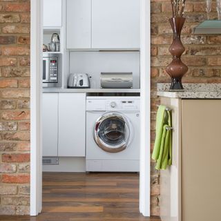 washing machine visible through doorway in a kitchen