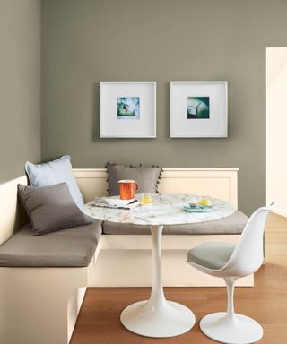 dining area with a L shaped bench seat and a round marble effect table on a wooden floor