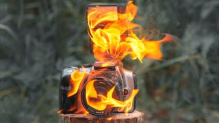 A DSLR with a lens and flash surrounded by flames