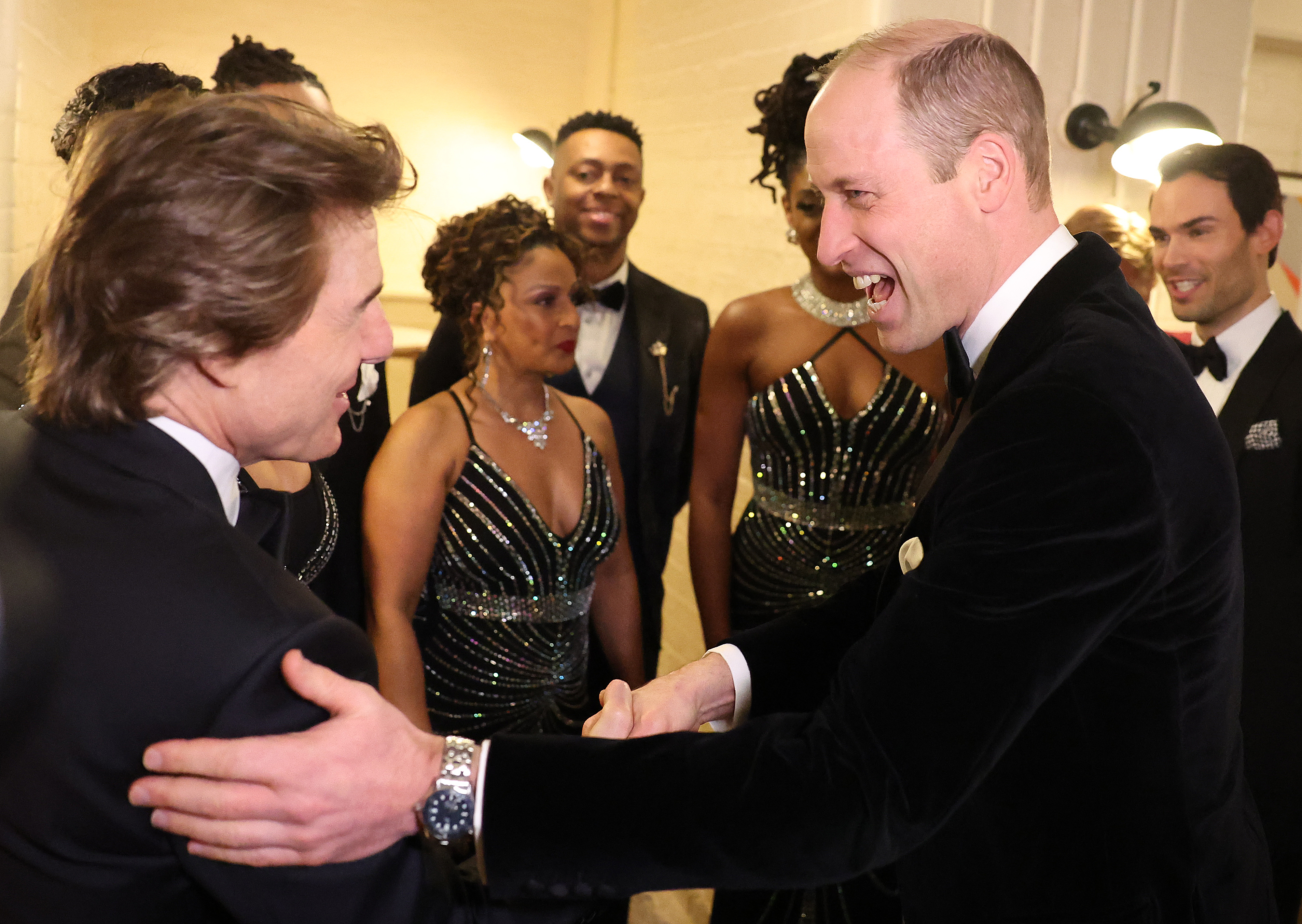 Prince William touching Tom Cruise's arm and laughing