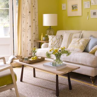 living room with yellow walls and white sofa set with cushions