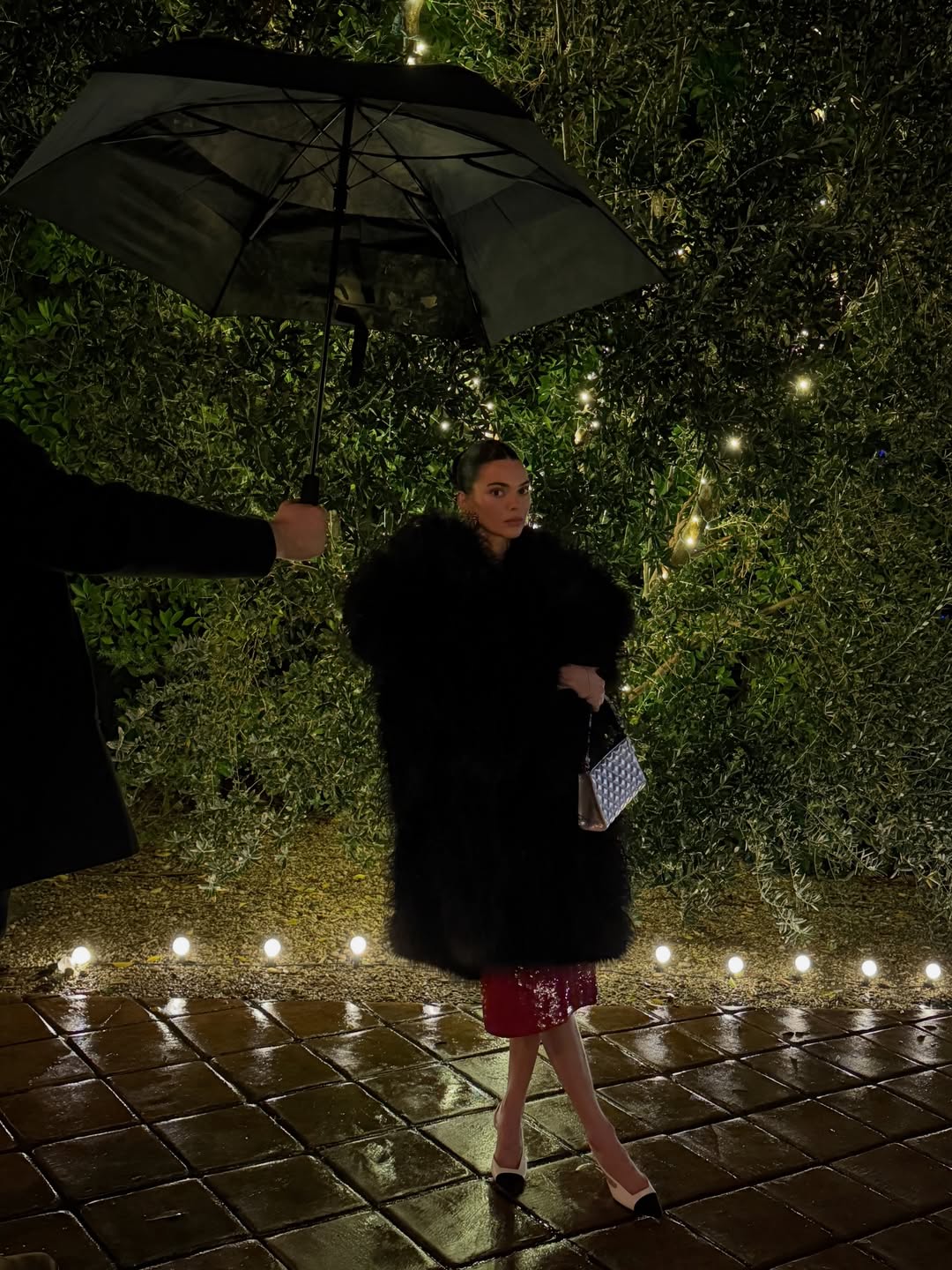 Kendall Jenner wears a Chanel runway outfit and carries a silver holiday collection quilted shoulder bag