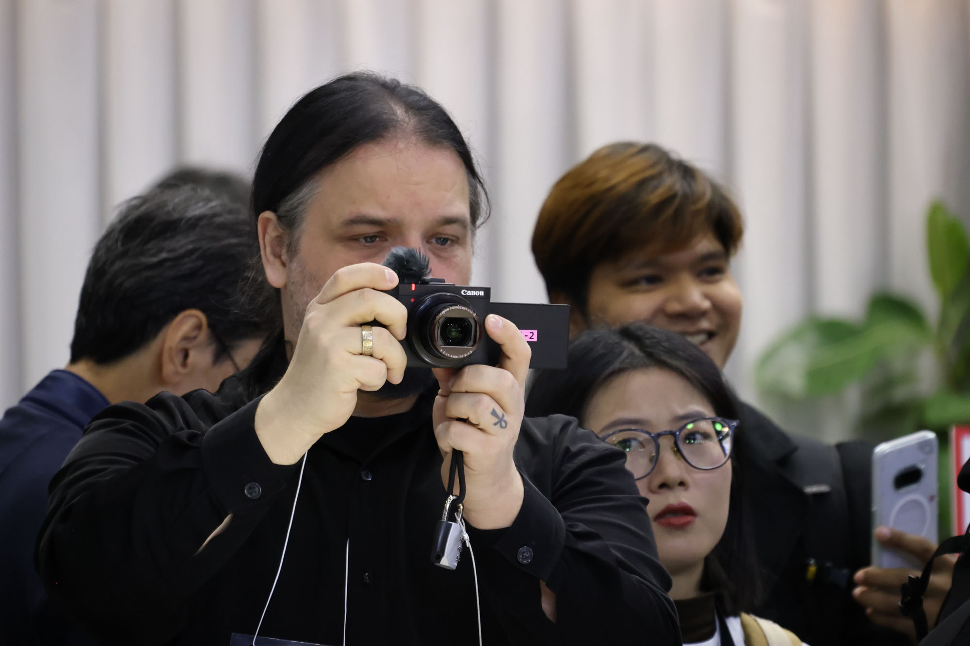 People getting hands-on with the Canon PowerShot V1 compact camera at the CP+ 2025 photography show