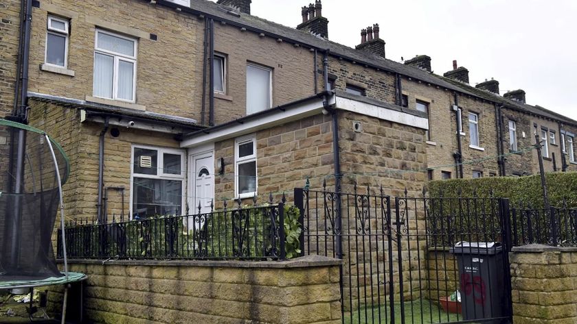 A brick rear extension with an AstroTurf back garden