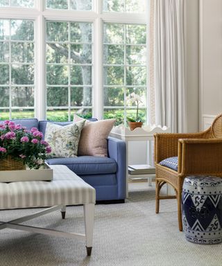 sunroom living room with a blue sofa and large windows