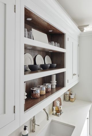 Open fronted kitchen cabinet with wood shelves and decorative display