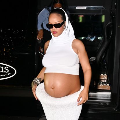 Rihanna wearing a white skirt set with a white hood
