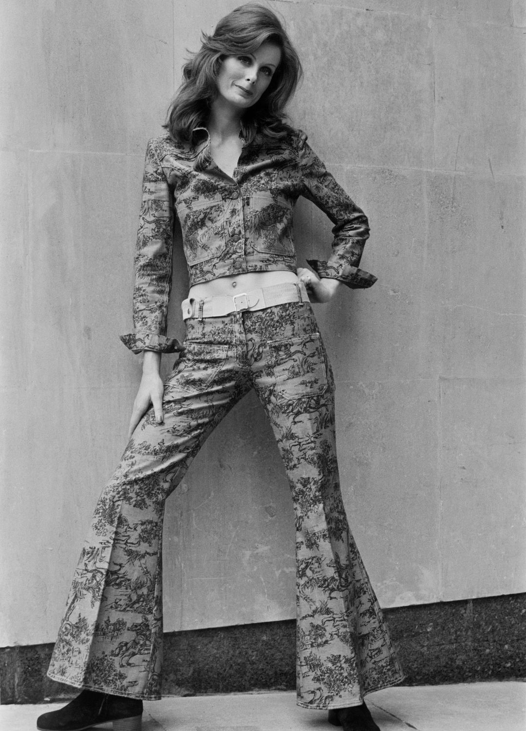 A model wearing a flared trouser suit in a floral fabric, UK, 1st May 1972.