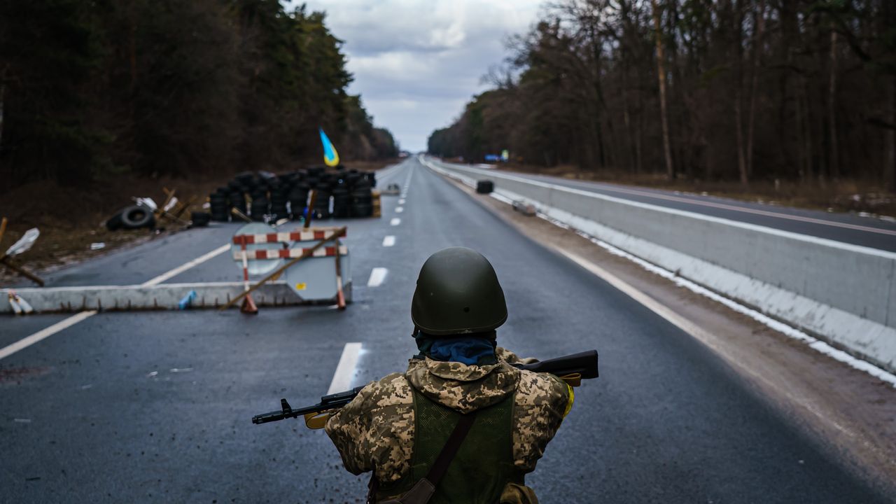 A Ukrainian soldier stands guard at a checkpoint outside Brovary