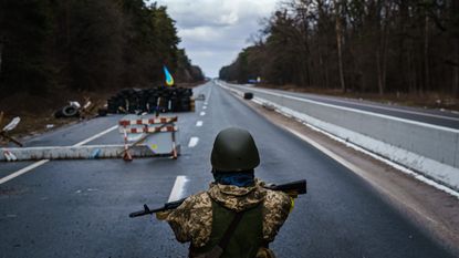 A Ukrainian soldier stands guard at a checkpoint outside Brovary
