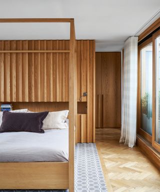 a bedroom with wood paneled walls and closet doors