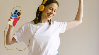 ZTE Nubia Music phone held by a woman, listening to it with yellow wired headphones