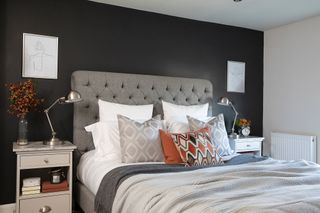 Hutchinson house: bedroom with dark feature wall and grey upholstered headboard