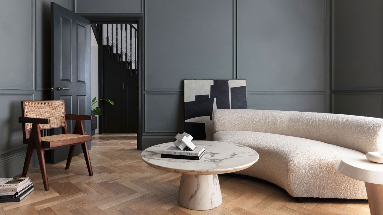 Kelly Hoppen&#039;s rule of four in a dark gray living room with cream furniture and wooden floor 