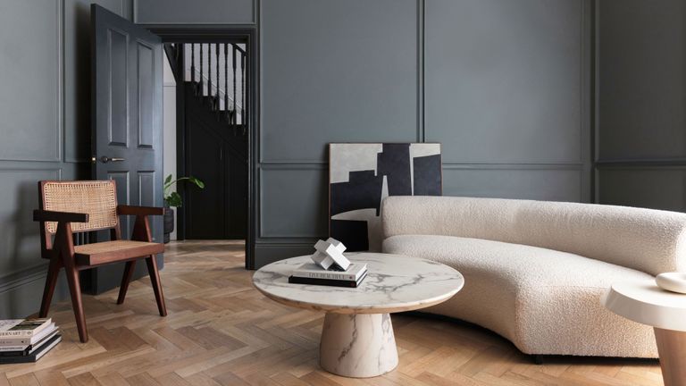 Kelly Hoppen's rule of four in a dark gray living room with cream furniture and wooden floor 