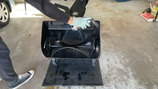 Snow blower being sprayed with silicone lubricant