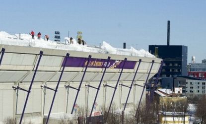 Workers shovel snow off of the Hubert H. Humphrey Metrodome Stadium whose inflatable roof collapsed this weekend under the weight of a massive snow storm.