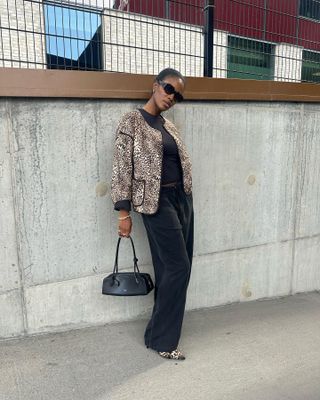 Marilyn Nwawulor-Kazemaks wearing a leopard-print jacket with black pants, leopard shoes, and an east-west bag.