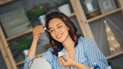 woman applying dropper to face