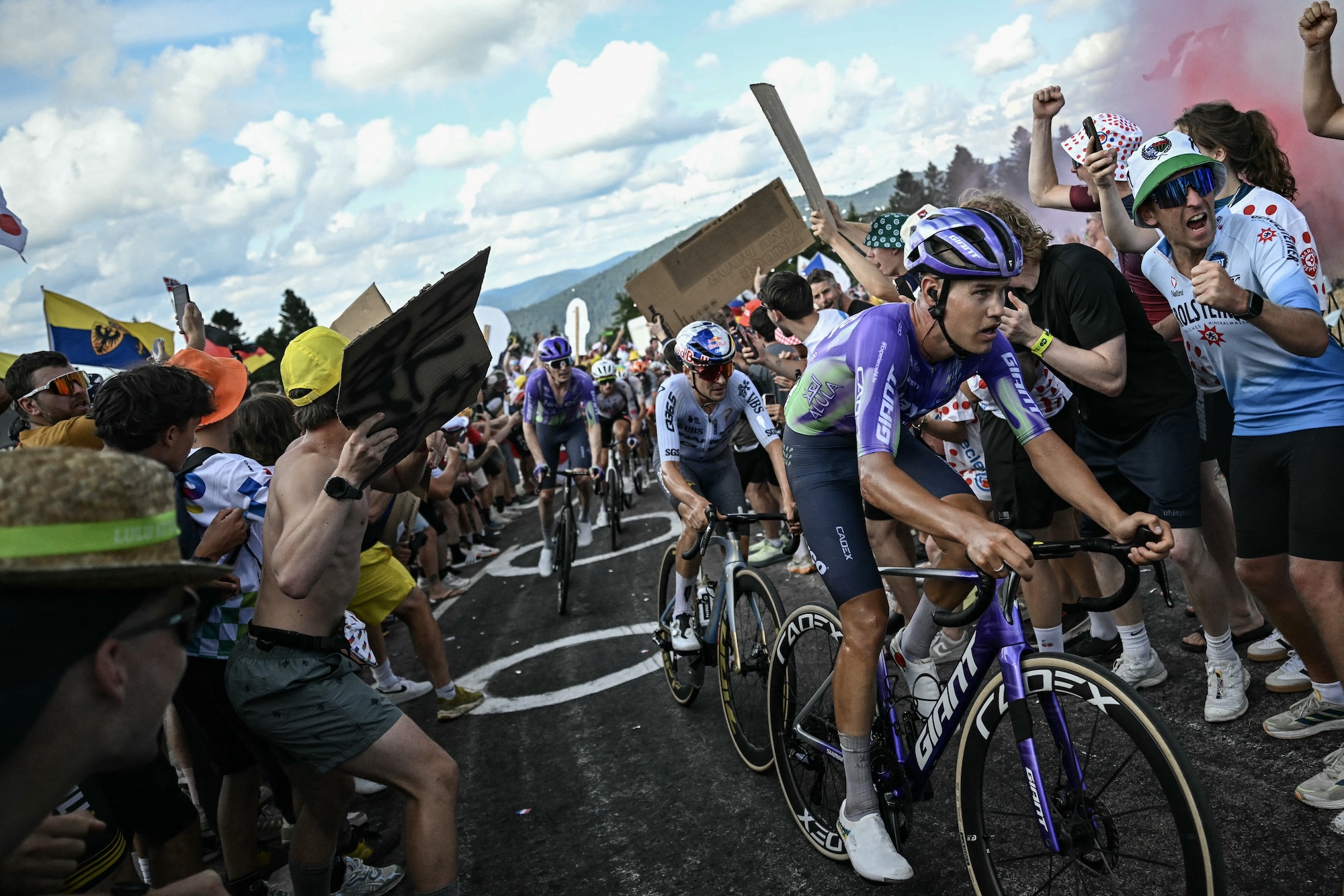 Team Jayco AlUla team's Luke Plapp (R) and Mauro Schmid ride with Pinarello Q36.5 Pro Cycling Team's Tom Pidcock (C) on the Ballon d'Alsace ascent