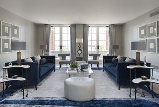 Grey living room with blue sofas by Joanna Wood