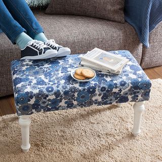 fabric footstool with shoes and biscuit on plate