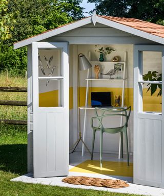Garden shed painted blue and yellow and set up as a home office in garden