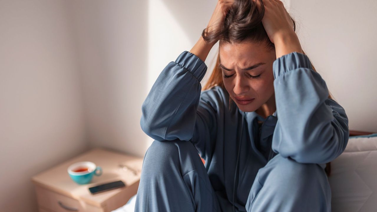 How to reduce stress: A woman with her head in her hands