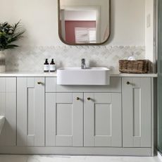 neutral en suite bathroom with fish scale tiles and vanity unit and cupboards