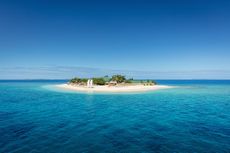 Fiji Mamanuca Islands Beautiful Small Islet in the middle of the south pacific ocean with beach huts, lounge chairs, palm trees, surrounded with beautiful clear turquoise water. Islet, Mamanuca Islands, Fiji, Melanesia
