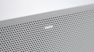 A close-up of the Sonos Ray's speaker grille with four lights illuminated through it