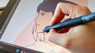 A close up of an artist doing line art on a large drawing screen tablet