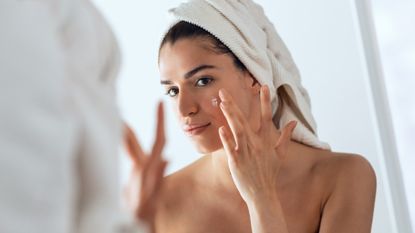 woman applying sulfur spot treatment to acne