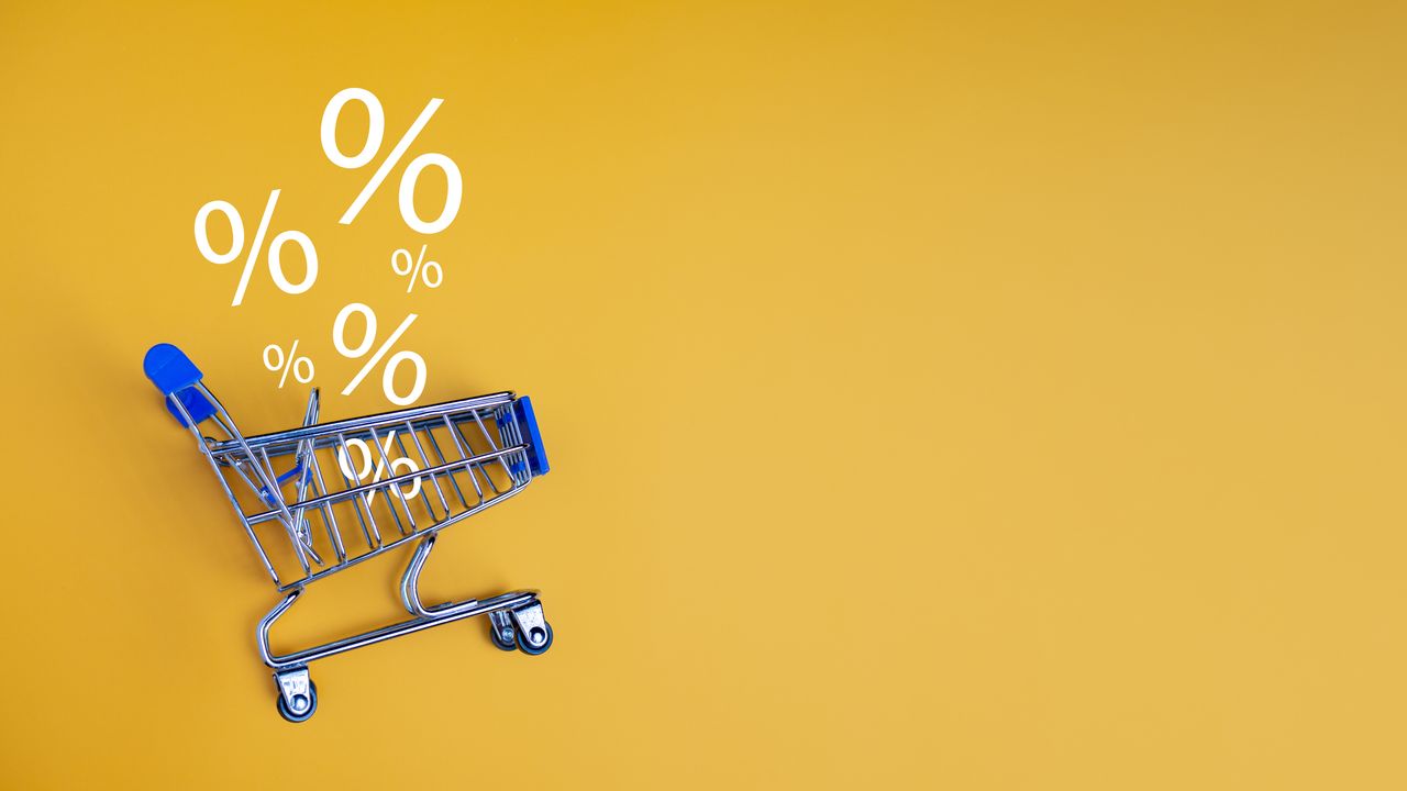 shopping cart with zero percent signs floating above it on a yellow background