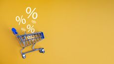 shopping cart with zero percent signs floating above it on a yellow background