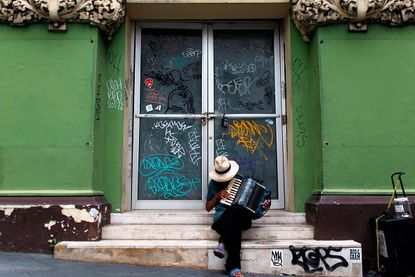 A man sits outside a closed business in Puerto Rico after Hurricane Maria.