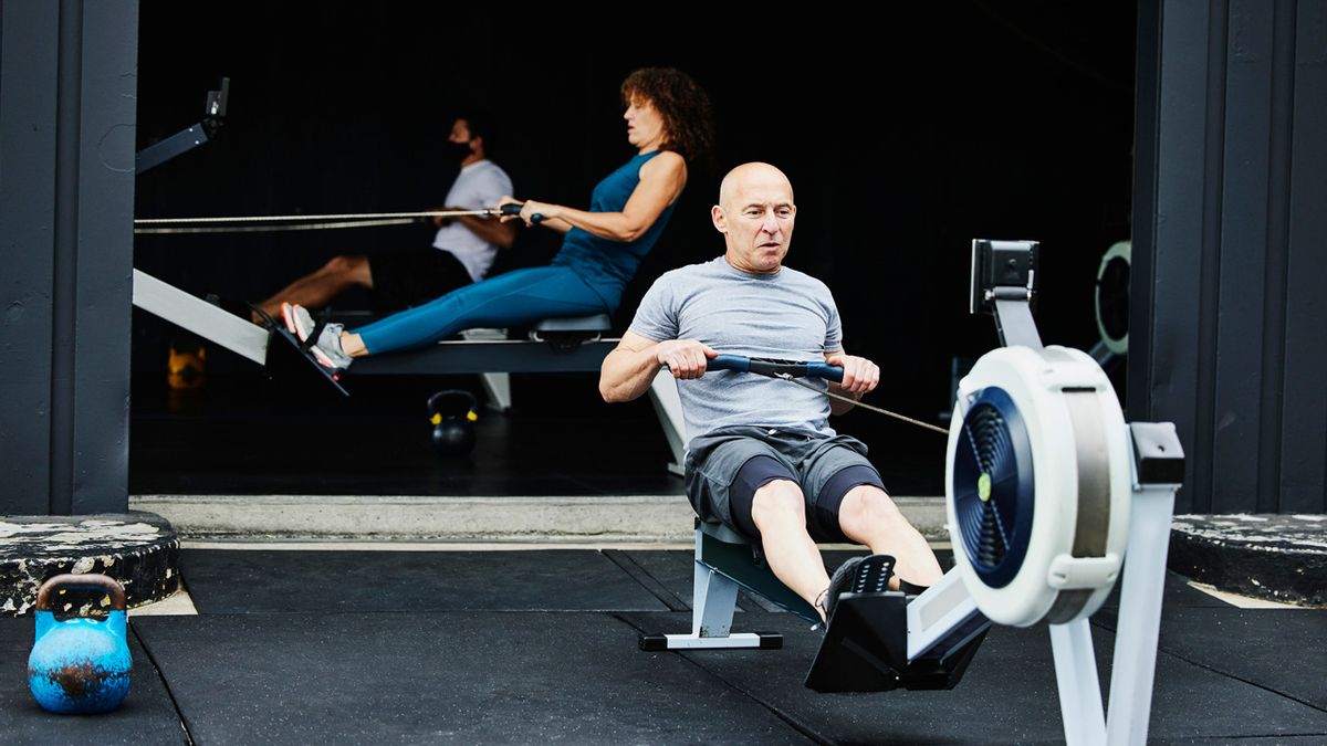 Man using rowing machine in a CrossFit gym outdoors