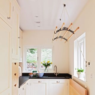 utility room with laundry maid cream cabinetry and black worktops