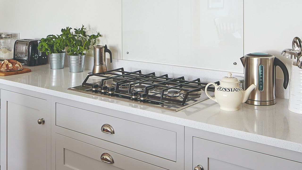 A grey kitchen with a gas cooker and small kitcehn appliances