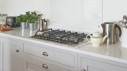 A grey kitchen with cream and silver kitchen appliances