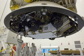 Technicians work beneath NASA's Mars Science Laboratory (MSL) mission aeroshell (containing the compact car-sized rover Curiosity).