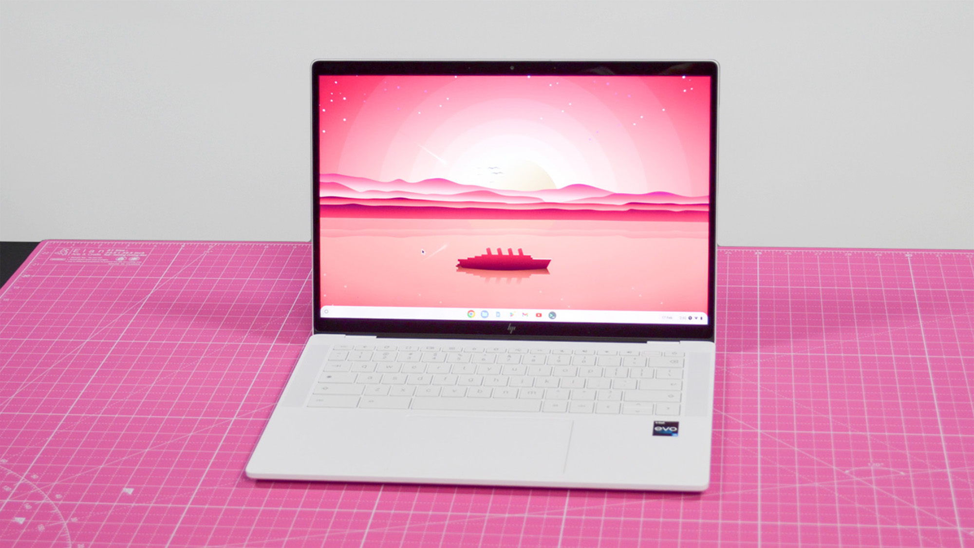 An HP Dragonfly Pro Chromebook on a ruled pink desk mat